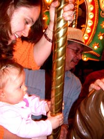 Eva and Gretchen on the merry-go-round. 
                  Susan Shie 2005.