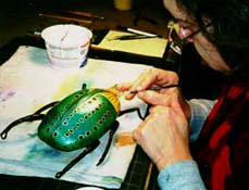 Putting final touches on a leather whiskey flask.