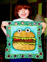 Benjamin Stern models his mom's Hamburger Cake, foe the Dishtowel Project Andi Stern 1998.