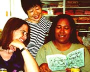 Tomasita reads my Lucky Signs book to Judy and Yoshiko.Susan Shie 2001.