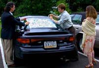 Putting sign on car. Susan Shie 2003.